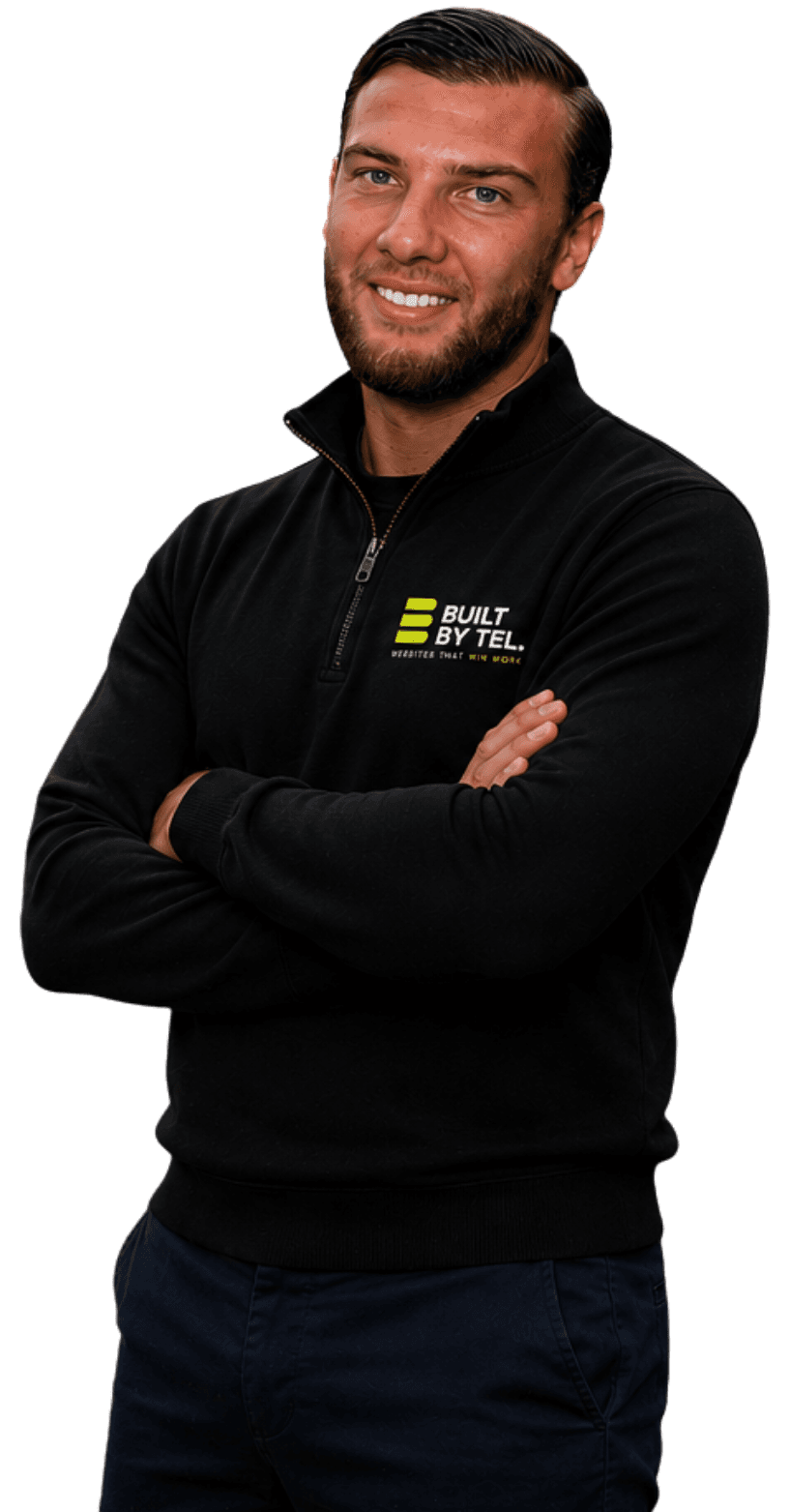Tel, founder of Built By Tel, in a branded Built By Tel quarter-zip